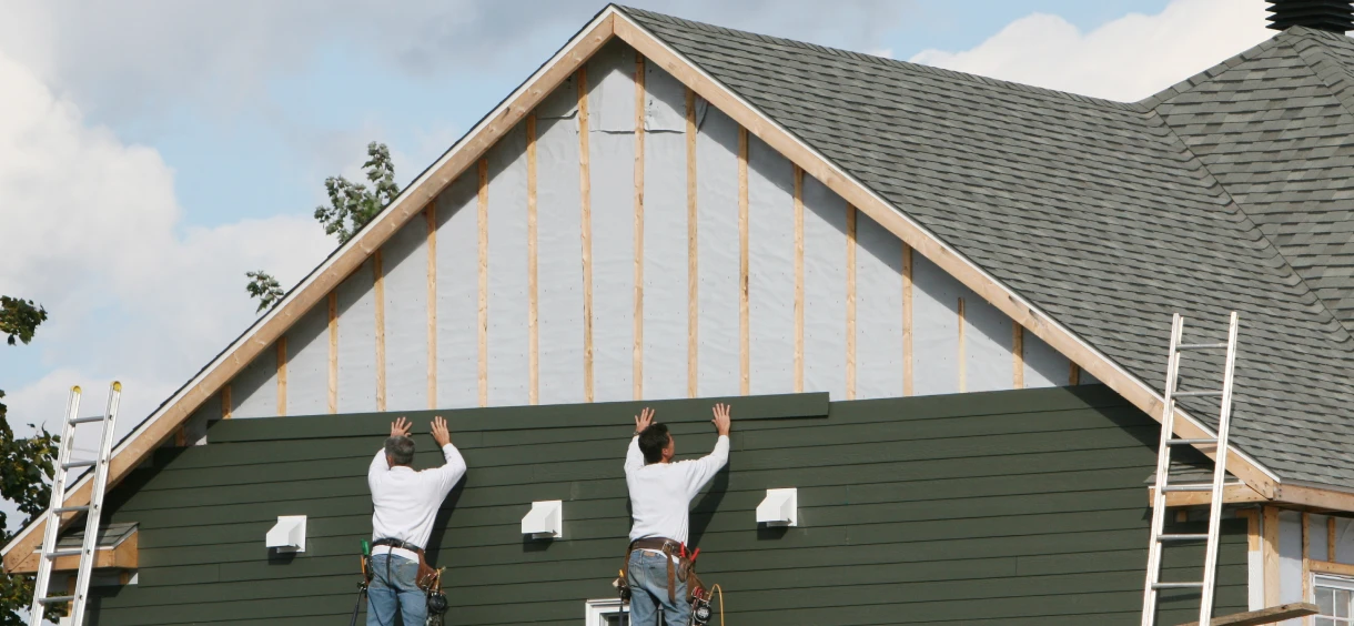 Workers installing house siding